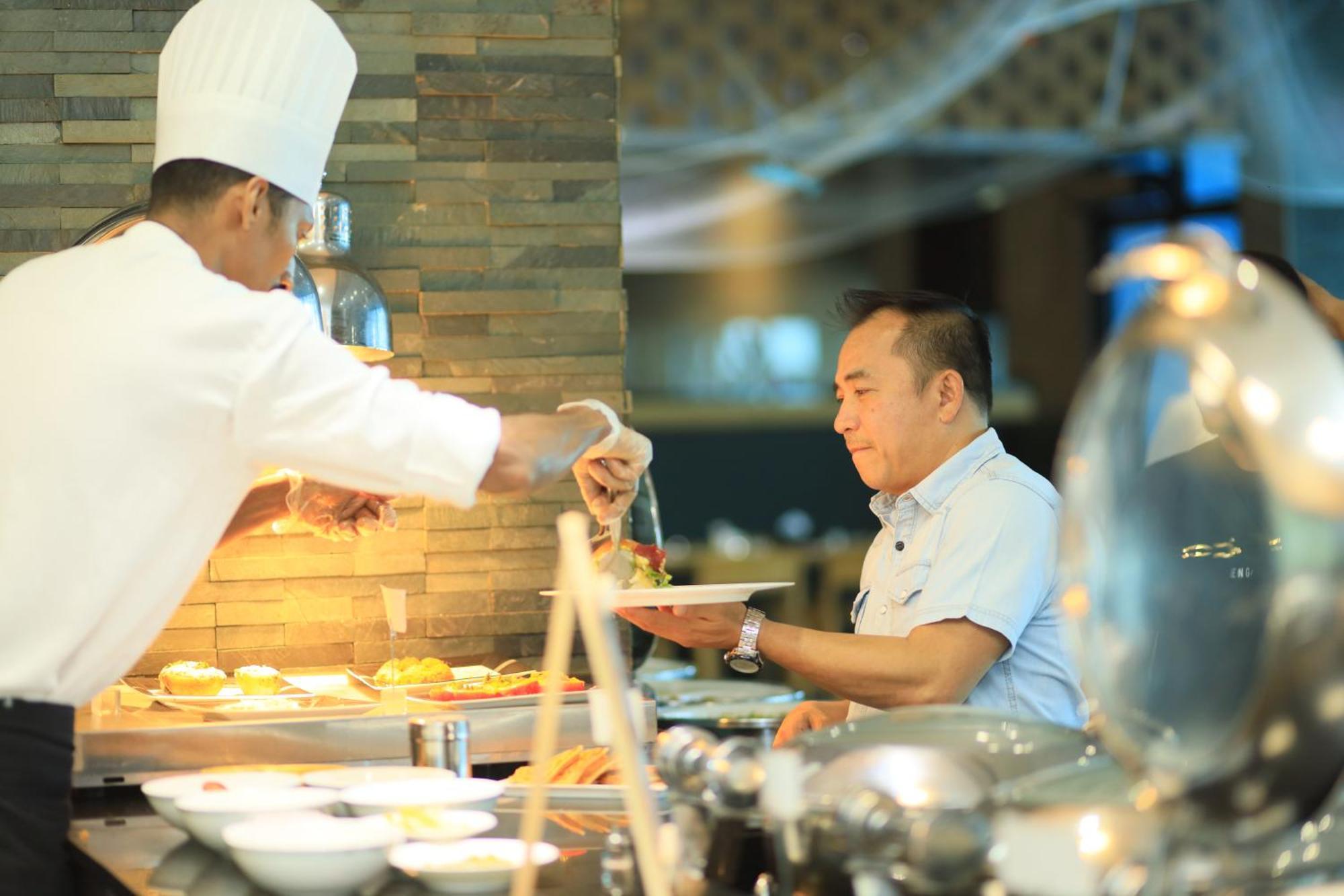 Ramee Grand Hotel And Spa Al-Manamah Bagian luar foto A chef serving food at a buffet